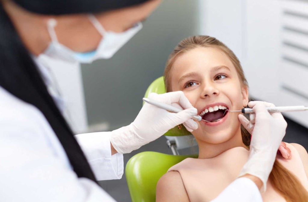 A young girl visiting her dentist for a routine exam and cleaning to ensure healthy oral habits