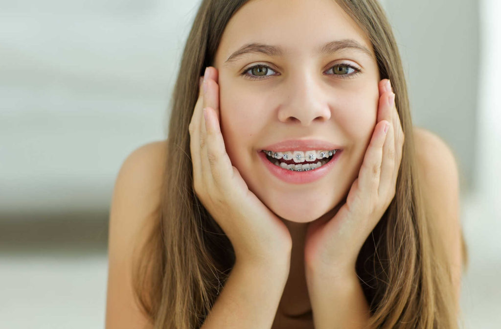 A female teenager is showing her teeth with braces. Braces to help relieve the pain, pressure, and discomfort associated with TMJ.