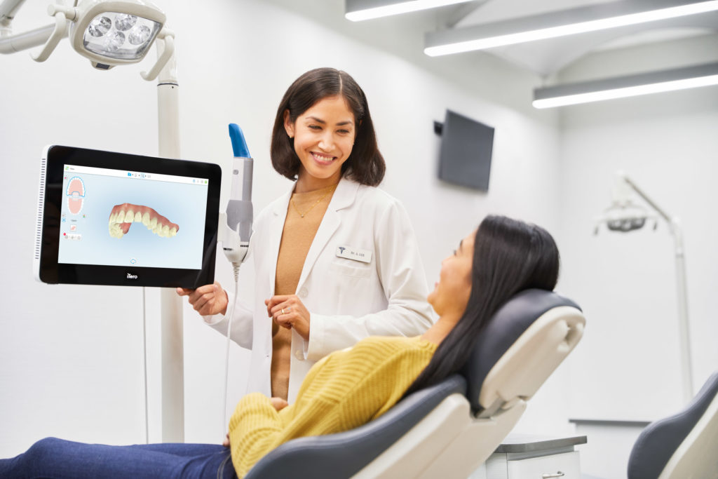 A dentist using the iTero scanner on a patient during a Invisalign appointment at a dental clinic.