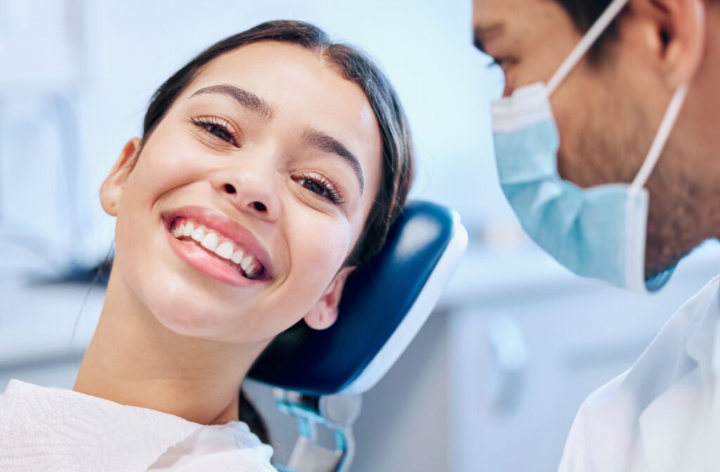A close-up image of a patient smiling at their dentist after a professional teeth cleaning.