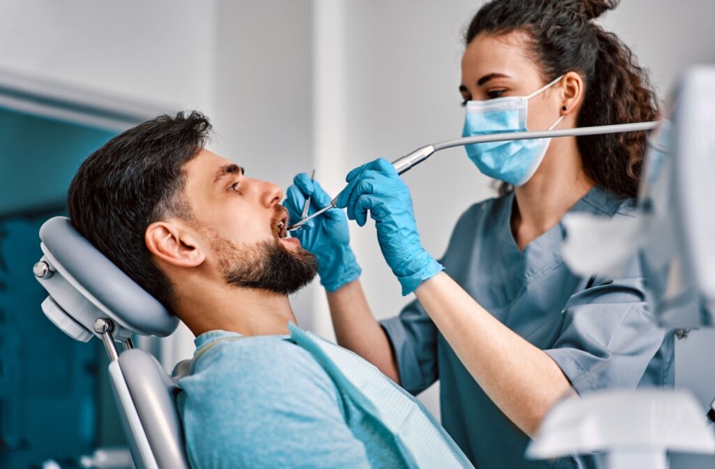 A dental patient having their teeth cleaned during a comprehensive dental exam and cleaning.